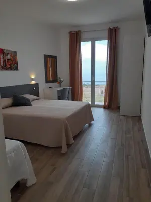 a bedroom with a bed and a large window at Bed and Breakfast Stella del Sud Makari in Macari