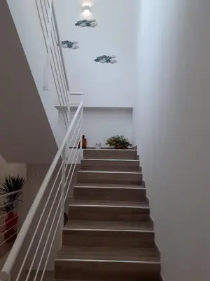 a staircase in a house with white walls and wooden floors at Bed and Breakfast Stella del Sud Makari in Macari