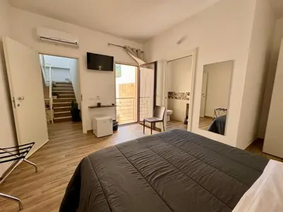 a bedroom with a bed and a chair in a room at Bed and Breakfast Stella del Sud Makari in Macari