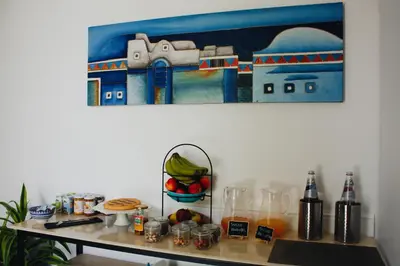 a table with food and a painting on the wall at AWA Mondello in Mondello
