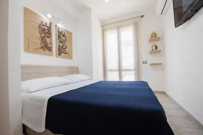 a bedroom with a bed with a blue blanket at Sea Vito Apartment in San Vito lo Capo