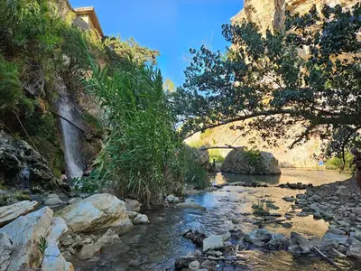 a stream with a waterfall and trees and rocks at Casa vacanza Corallo in Castellammare del Golfo