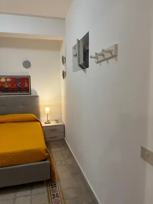 a bedroom with a bed and a tv on the wall at Casa di fronte la Cattedrale in Palermo