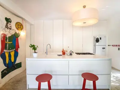 a kitchen with white cabinets and red stools at Villa Re di Denari by Interhome in Terrasini