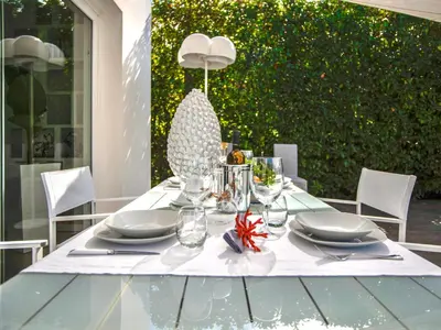 a table with plates and glasses and a vase on it at Villa Re di Denari by Interhome in Terrasini