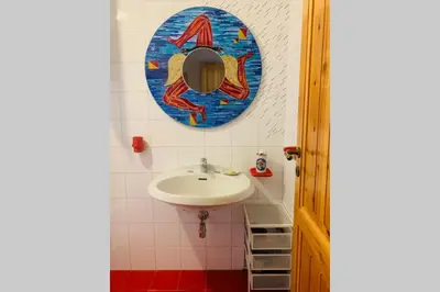 a bathroom with a sink and a mirror on the wall at Villa dell’Orsa in Cinisi