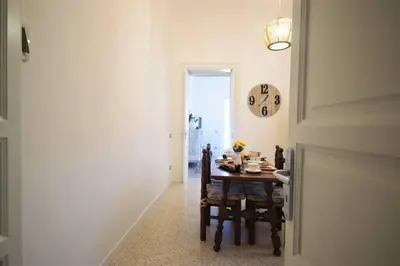 a dining room with a table and a clock on the wall at La Casetta 90139 in Palermo