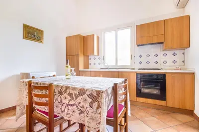 a kitchen with a table with chairs and a window at Case Vacanze Paradise Beach Vicino Cefalù PISCINA APERTA in Campofelice di Roccella