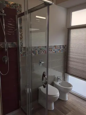 a bathroom with a shower and a toilet and a sink at George House Palermo in Palermo
