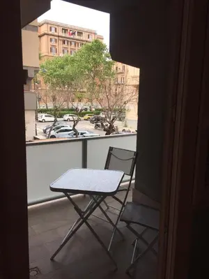 a table and a chair on a balcony at George House Palermo in Palermo