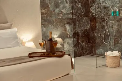a white bedroom with a bed and a mirror at Palermo Inn Boutique Hotel in Palermo