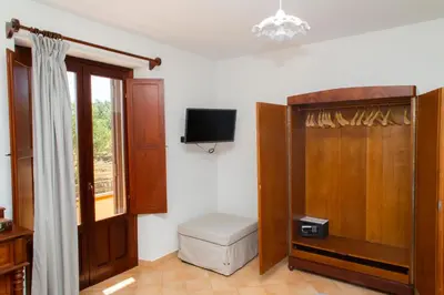 a bathroom with a toilet and a tv and a window at Feudo Giglio Country Charme in Calatafimi