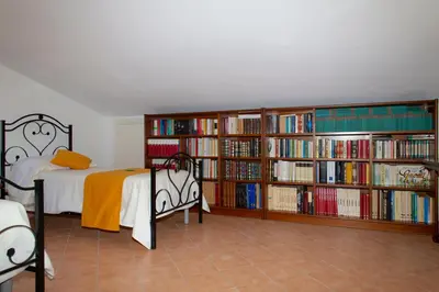 a bedroom with a bed and book shelves filled with books at Feudo Giglio Country Charme in Calatafimi