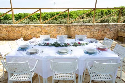 a white table with white chairs and flowers on it at Feudo Giglio Country Charme in Calatafimi