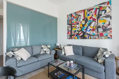 a living room with a couch and a painting on the wall at Loft Trinacria con Vista Mare by Wonderful Italy in Palermo