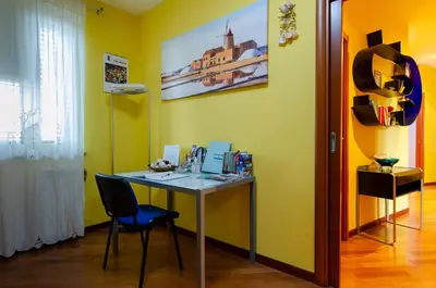 a desk with a chair in a room with yellow walls at POLICLINICO HOME in Palermo
