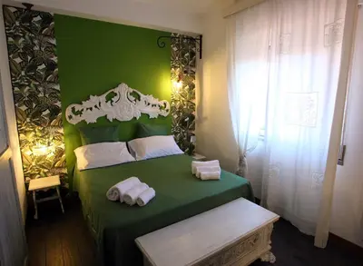 a green bedroom with a bed with towels on it at Accardi House Searooms in Palermo