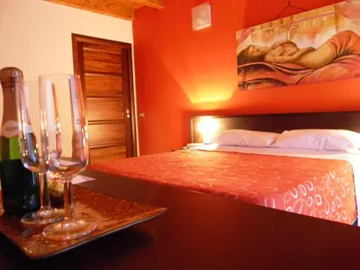 a bedroom with a bed and a table with wine glasses at B&B Oreto Centro in Palermo