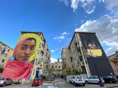 a mural of a woman on the side of two buildings at Casa dello Spasimo in Palermo