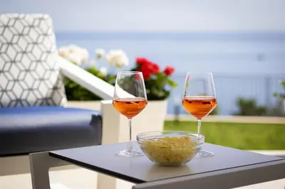 two glasses of wine and a bowl of food on a table at Kafara Resort- Villas and Pool by Lisca Bianca Rental in Santa Flavia