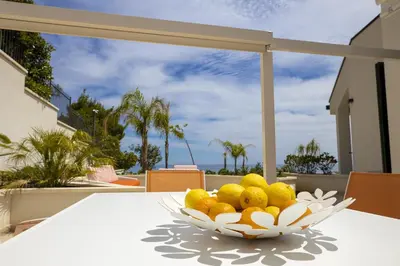 a bowl of fruit on a table with a view of the ocean at Kafara Resort- Villas and Pool by Lisca Bianca Rental in Santa Flavia