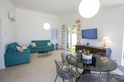 a living room with a table and a blue couch at Kafara Resort- Villas and Pool by Lisca Bianca Rental in Santa Flavia