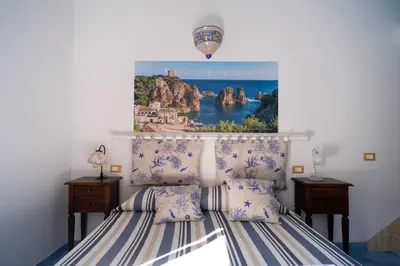 a bedroom with a bed with a poster on the wall at la palma in Castellammare del Golfo
