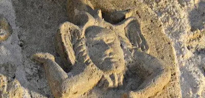 a stone carving of a person on the ground at la palma in Castellammare del Golfo