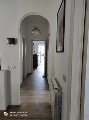 a hallway of a home with white walls and wooden floors at La casa di Giulio - holiday home in Isola delle Femmine