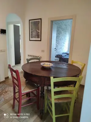 a dining room with a wooden table and chairs at La casa di Giulio - holiday home in Isola delle Femmine