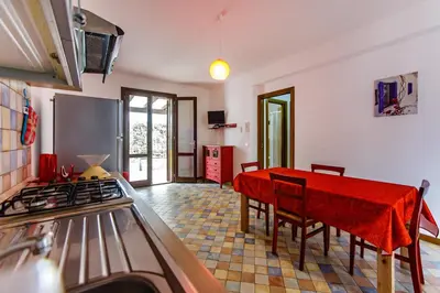 a kitchen with a table with a red table cloth at SanvitoTour - Oasi nel Mare in San Vito lo Capo