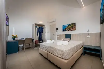 a bedroom with a bed and a desk in it at Affittacamere Nanà in Castellammare del Golfo