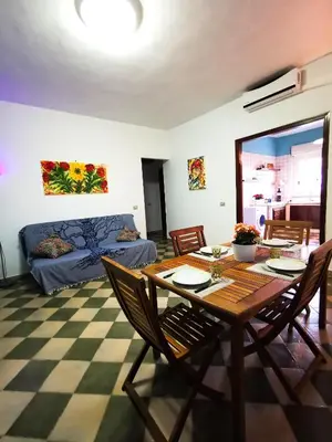 a dining room with a table and chairs and a bed at Frida casavacanze in Castellammare del Golfo
