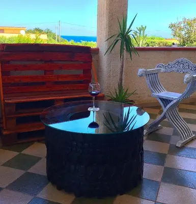 a wine glass sitting on top of a tire table at Frida casavacanze in Castellammare del Golfo