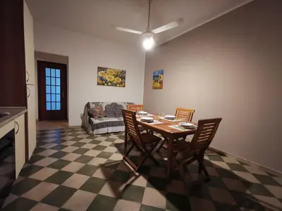 a dining room with a table and chairs and a couch at Frida casavacanze in Castellammare del Golfo