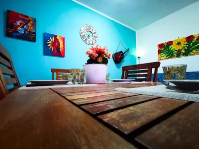 a dining room with a wooden table and a blue wall at Frida casavacanze in Castellammare del Golfo