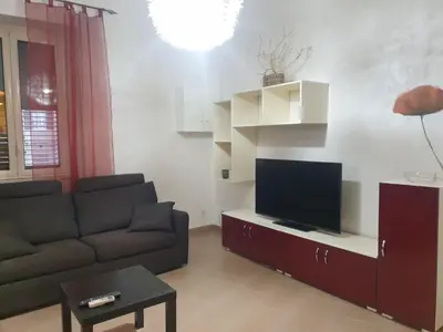 a living room with a couch and a flat screen tv at A Casa Tua in Palermo