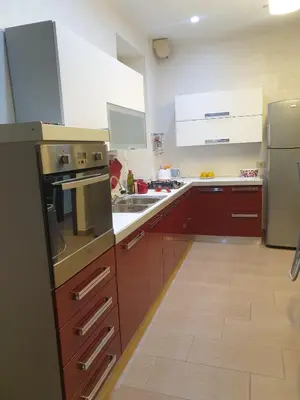 a kitchen with brown cabinets and stainless steel appliances at A Casa Tua in Palermo