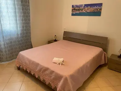 a bedroom with a bed with a flower on it at Appartamento Sunrise in San Vito lo Capo