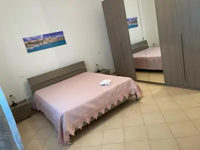 a bedroom with a bed and a mirror in it at Appartamento Sunrise in San Vito lo Capo