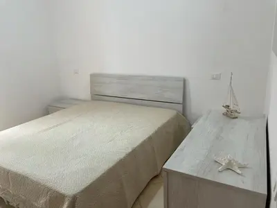 a bedroom with a bed and a table with a starfish on it at Appartamento Sunrise in San Vito lo Capo