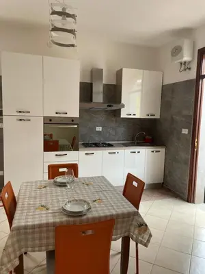 a kitchen with a table and chairs and a table at Appartamento Sunrise in San Vito lo Capo