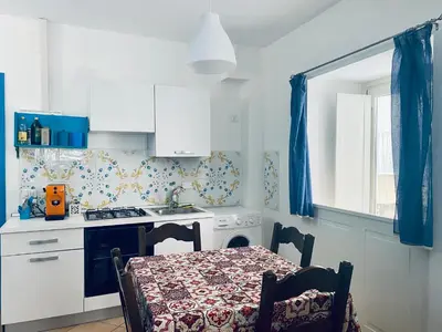 a kitchen with a table and a sink and a stove at Cartari Apartment in Palermo