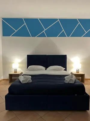 a bedroom with a large bed with two night stands at Cartari Apartment in Palermo
