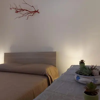 a bedroom with a bed and a table with potted plants at Villa Torre Magaggiari in Cinisi