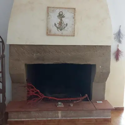 a stone fireplace with a picture on the wall at Villa Torre Magaggiari in Cinisi