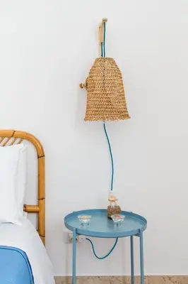 a lamp on a blue table next to a bed at Vento di Grecale - a pochi metri dal mare in Santa Flavia