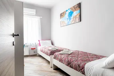 a bedroom with two beds and a window at Dream Home in Palermo