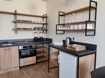 a kitchen with wooden cabinets and a black counter top at Le Métro in Carini