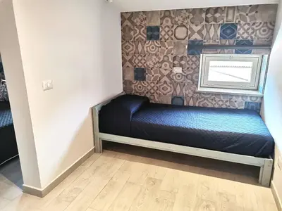 a small bed in a room with a wall at Le Métro in Carini